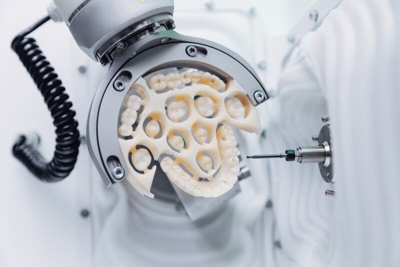 Cnc machine crafting dental veneers prosthesis with precision and detail.