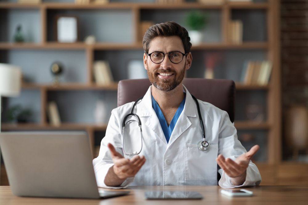 Handsome Male Doctor Sitting At Desk