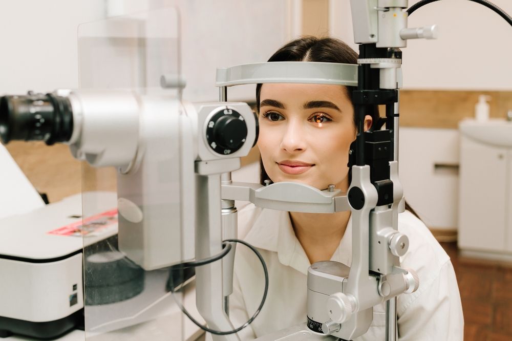 Ophthalmologist illuminates eye of patient with light from slit lamp to diagnose the eyes and cornea