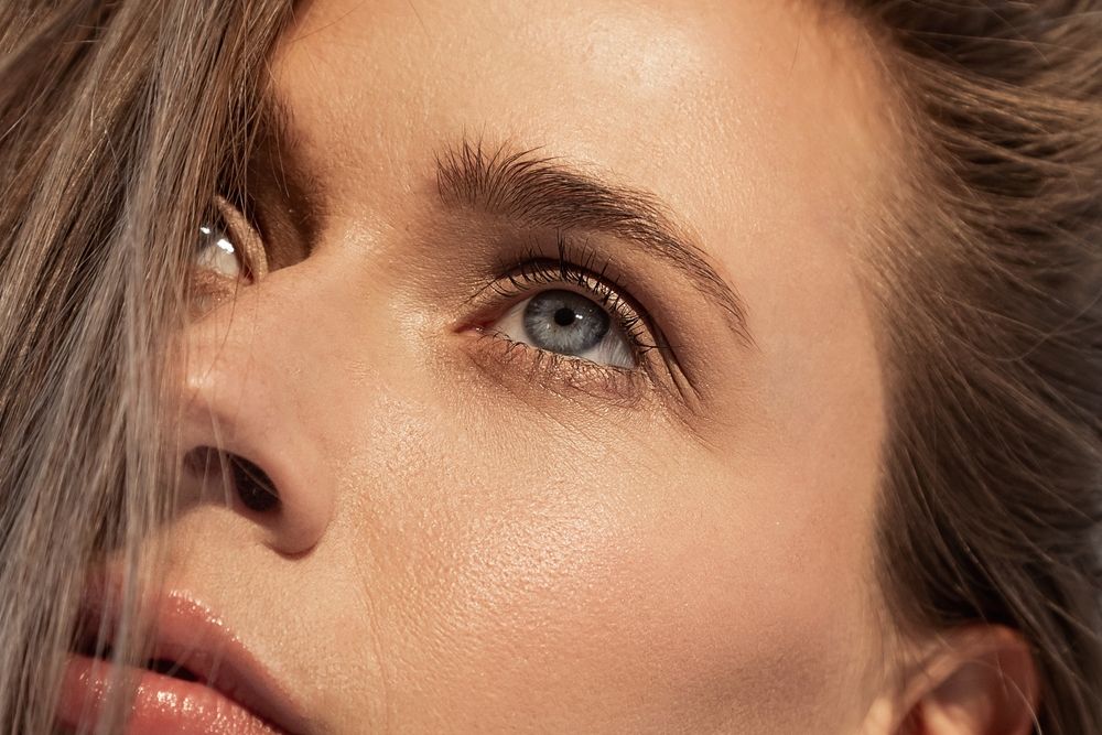 close-up portrait of a young girl with daytime make-up and blue eyes, nude. female looking up
