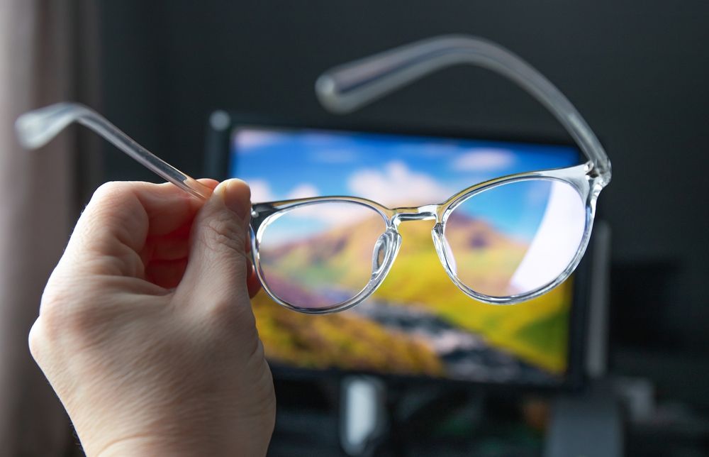 Selective focus on transparent clear blue light computer glasses and computer screen