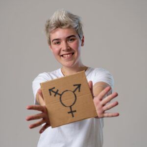 happy and proud trans teenager holding the symbol of the transgender