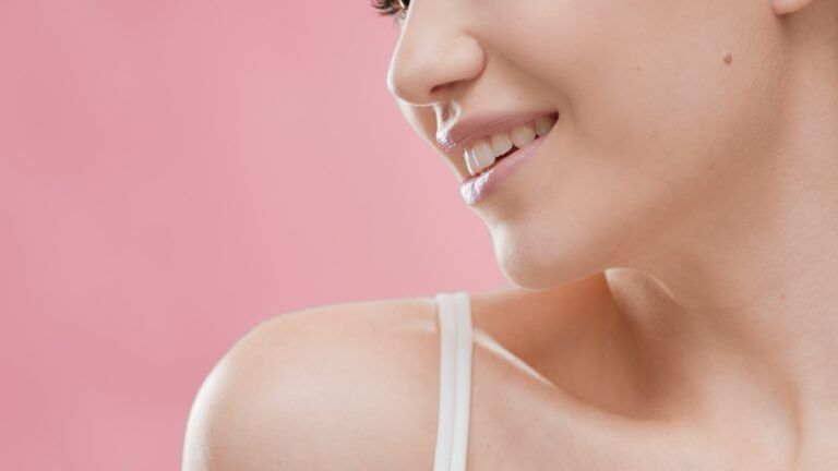 Young attractive woman in white bikini looks aside and smiles