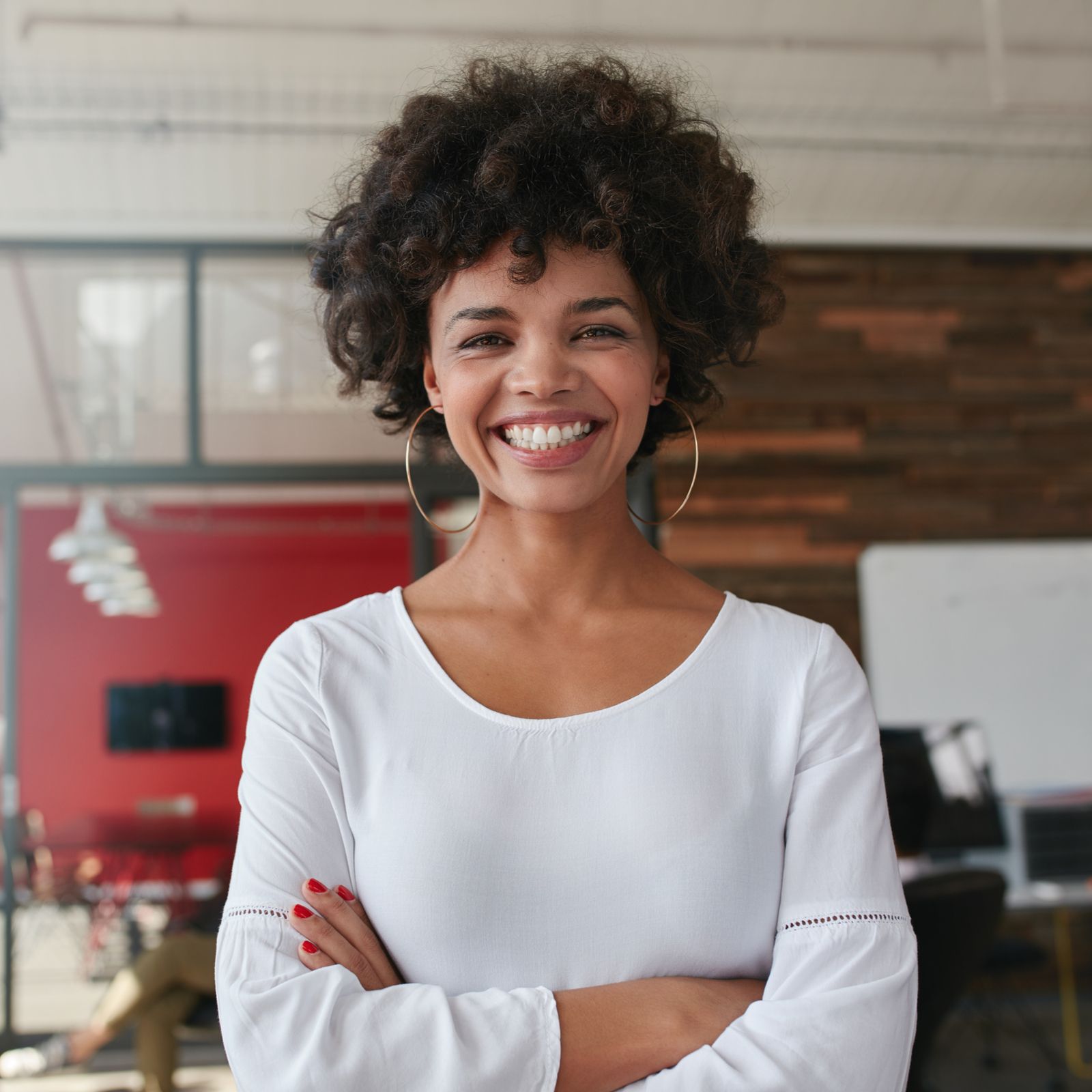 Smiling young woman standing with her arms crossed