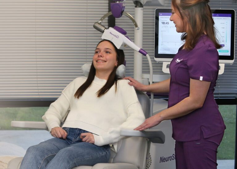 nurse giving transcranial magnetic stimulation treatment to patient