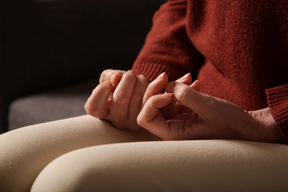 Close up of woman picking at cuticles, Skin picking disorder - classified as Obsessive-Compulsive and Related Disorders