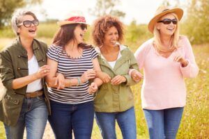 Group Of Mature Female Friends Walking Along Path