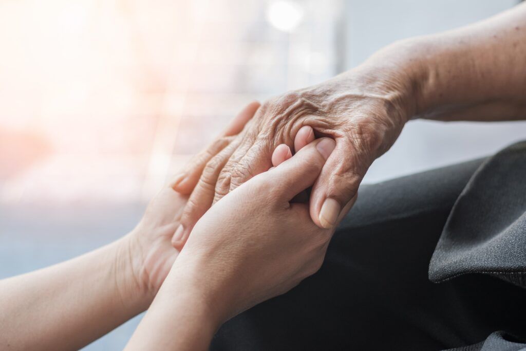 Nurse holding hand of elderly patient