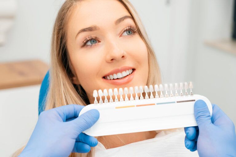 Women comparing teeth to veneers on display