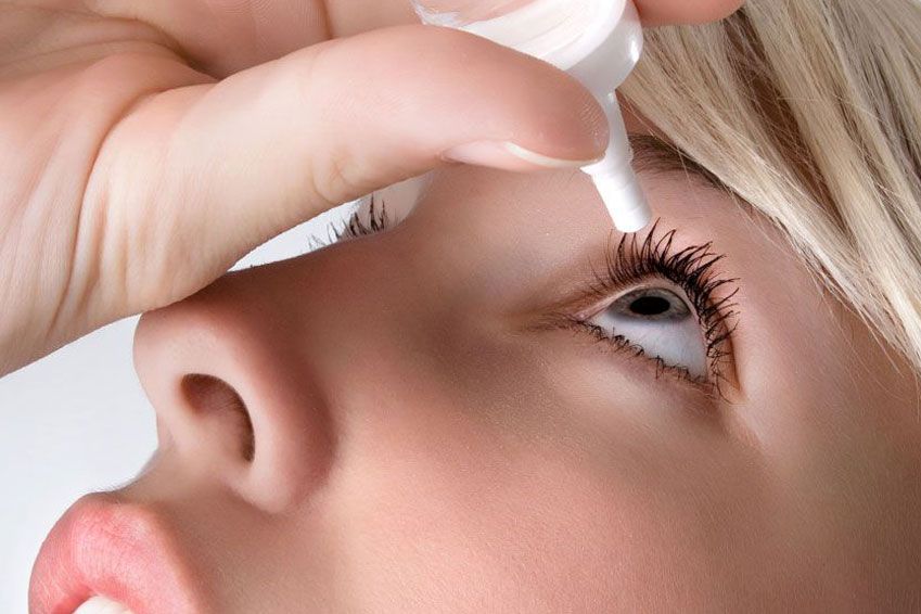 woman dripping her eye with medicinal drops