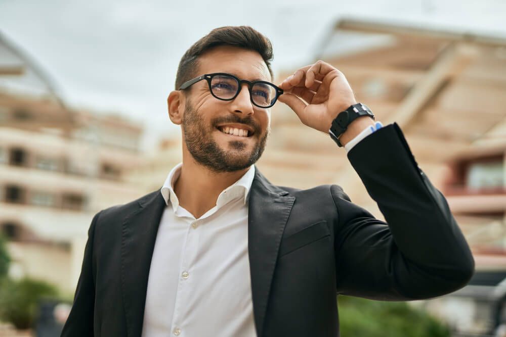 Young businessman smiling happy standing at the city