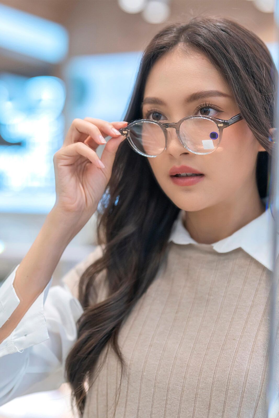 Woman choosing glasses in optical store