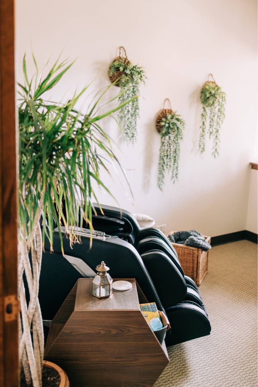 Zephyr Behavioral Health & Wellness office massage chair with a side table and plants on the walls