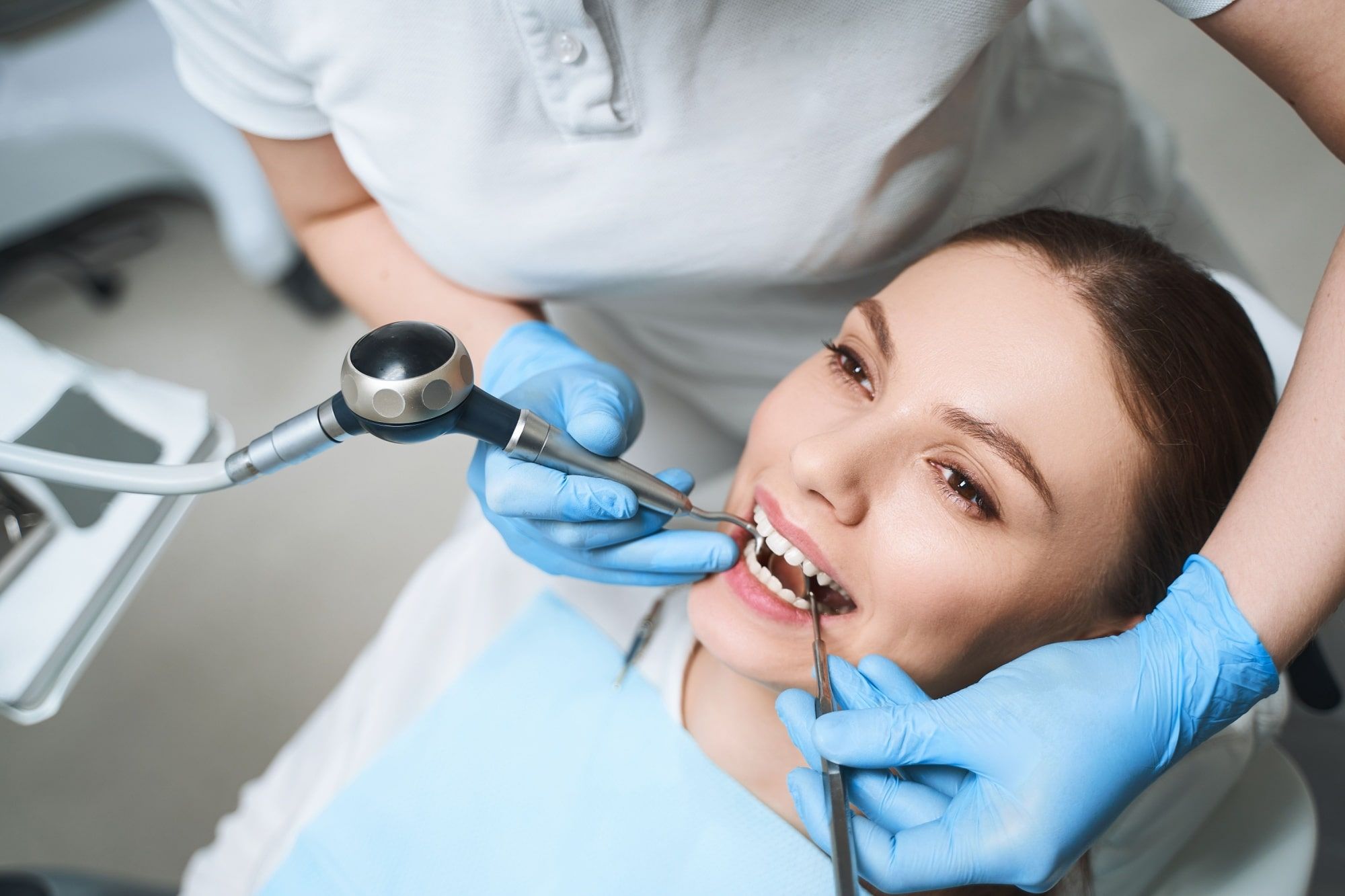 Young female on dental chair during procedures for healing her teeth