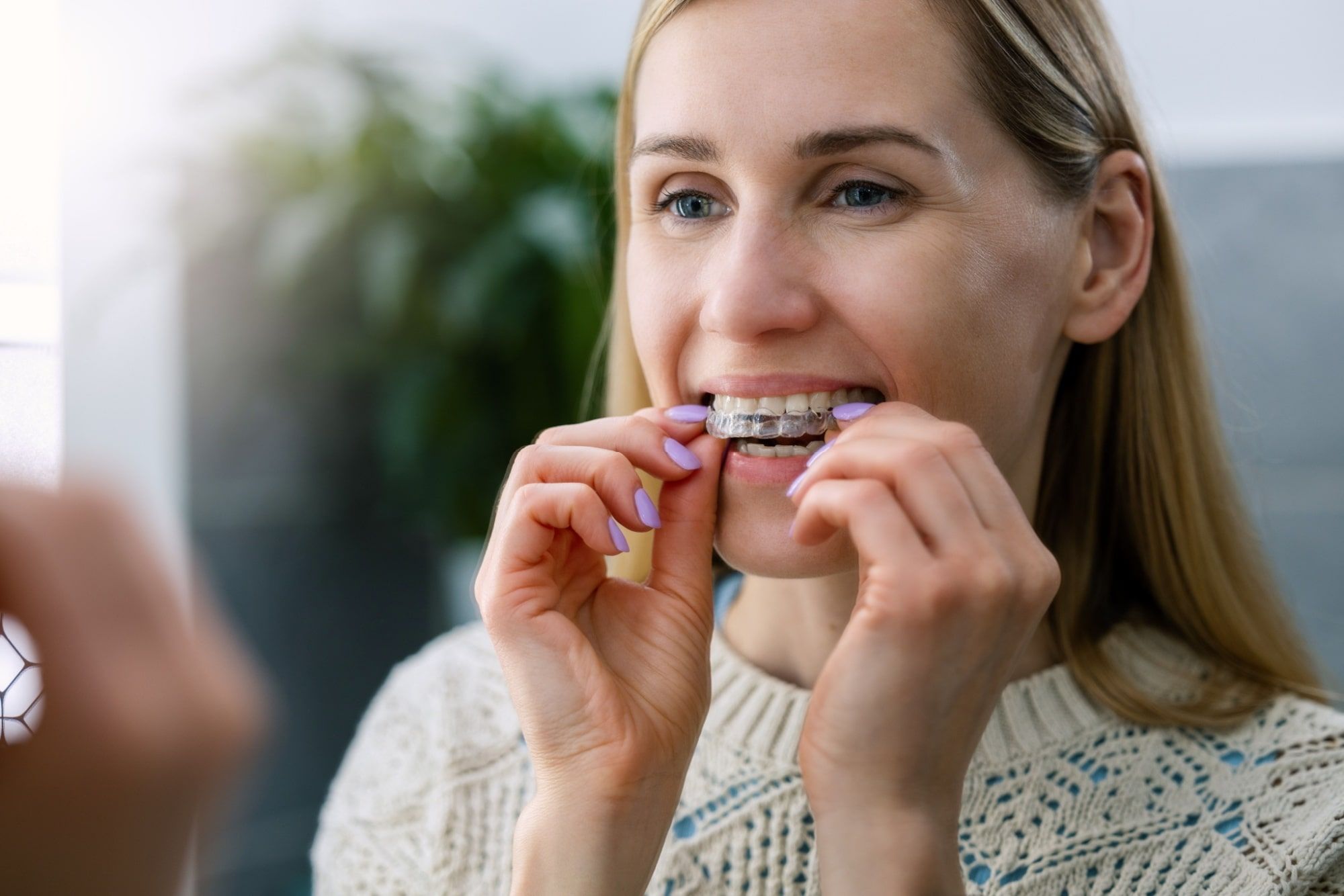 woman inserting transparent invisible dental aligners