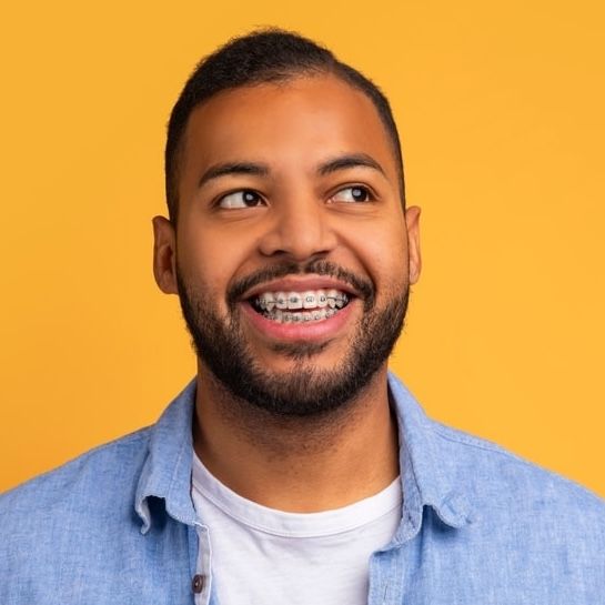 Smiling young man with orthodontic braces