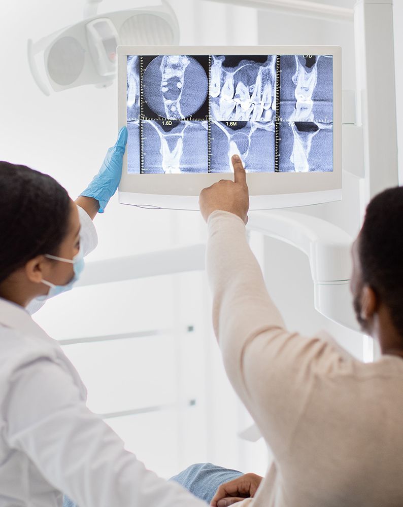 Female Stomatologist Showing Teeth Xray Picture On Digital Monitor