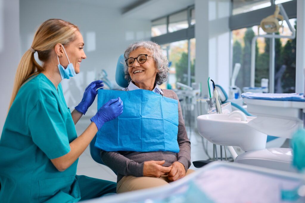 Happy elderly woman talking to her orthodontist during appointment