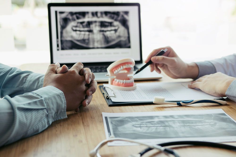 Dentists are discussing dental problems at report x-ray image