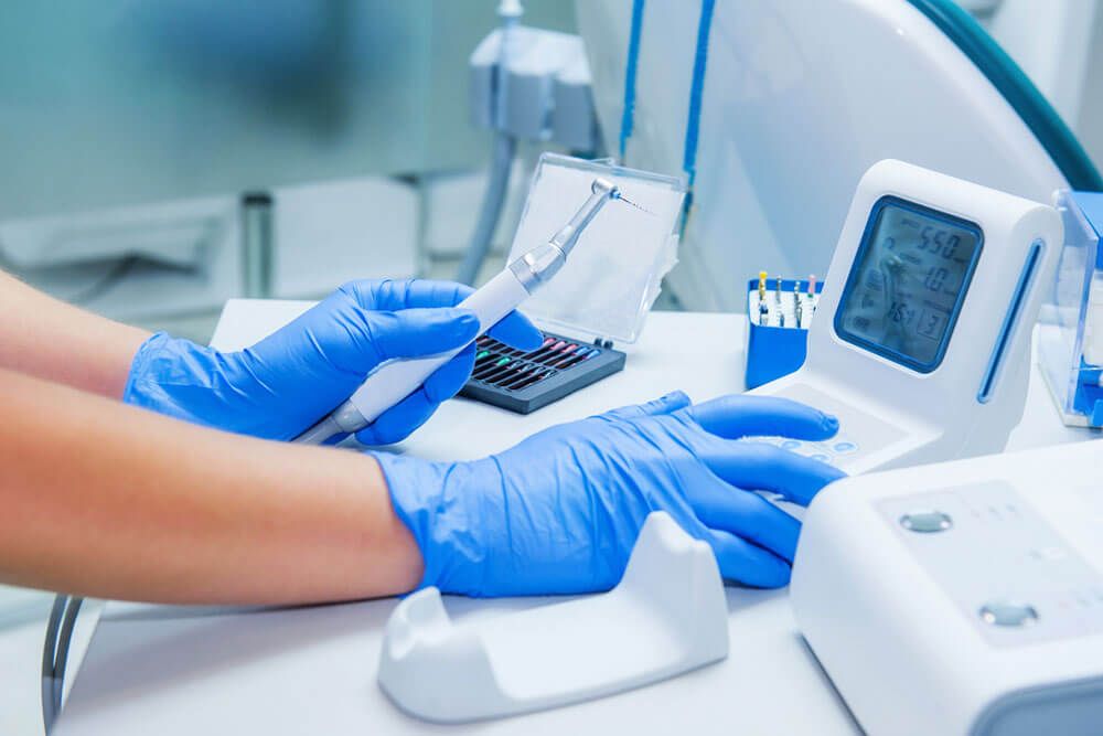 Assistant's hands configures dental equipment in dentist's office