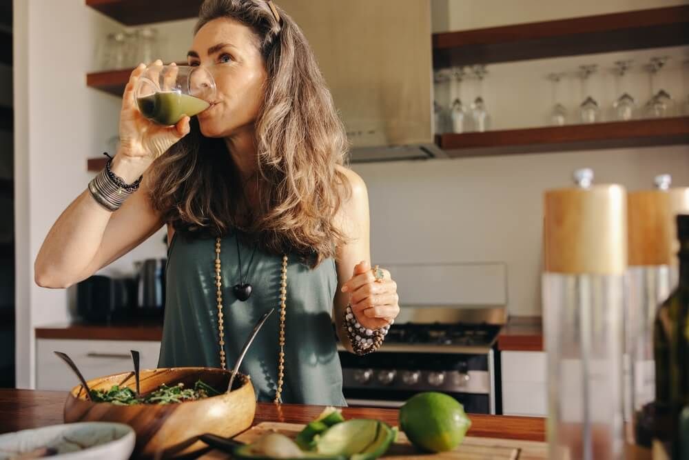 Vegan woman drinking some green juice