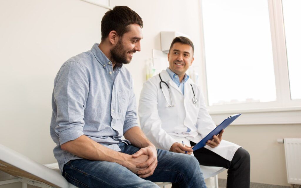 smiling doctor with clipboard and young man patient