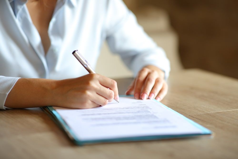 woman hands signing paper