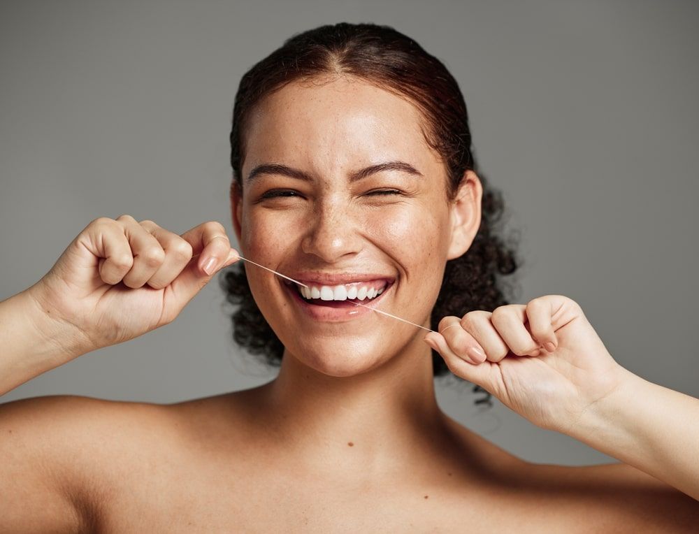 flossing teeth and woman with a smile