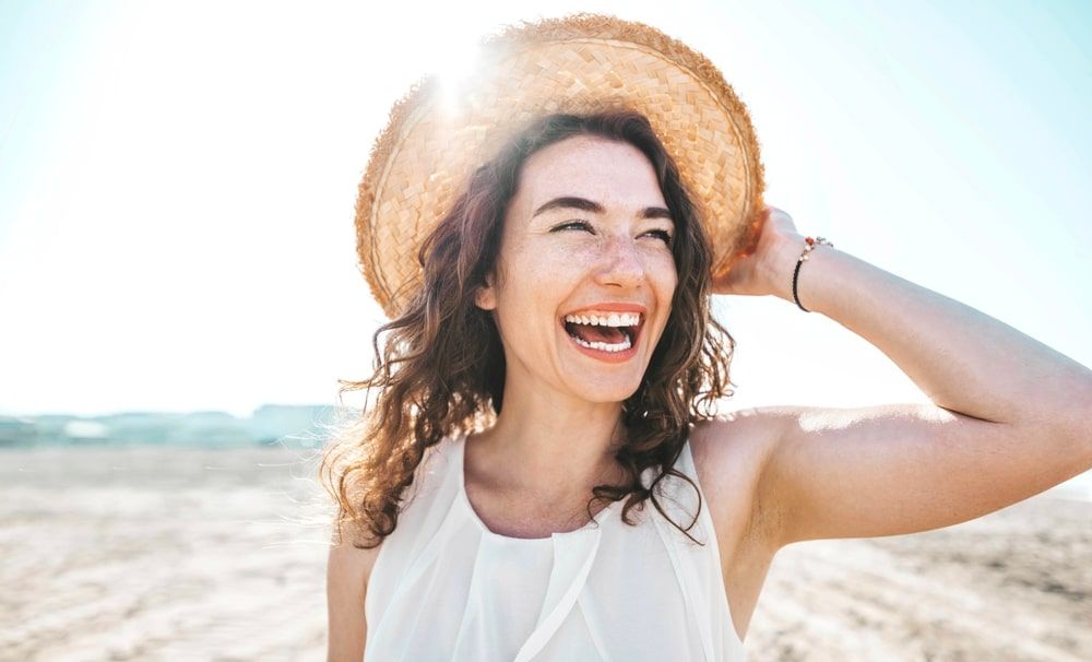 Happy beautiful young woman smiling at the beach