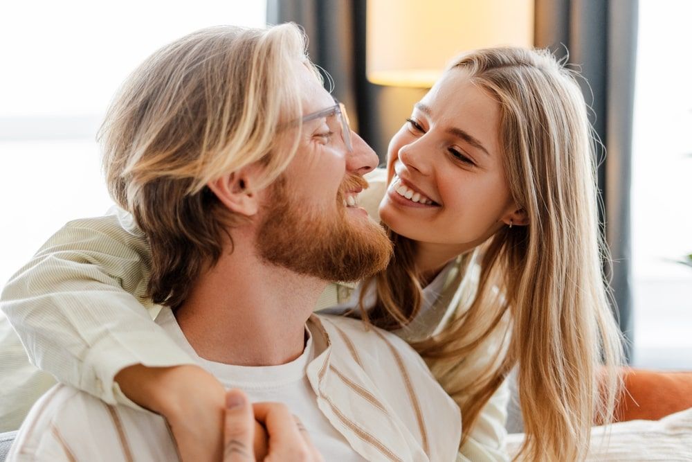 Happy young couple cuddling on the sofa at home,