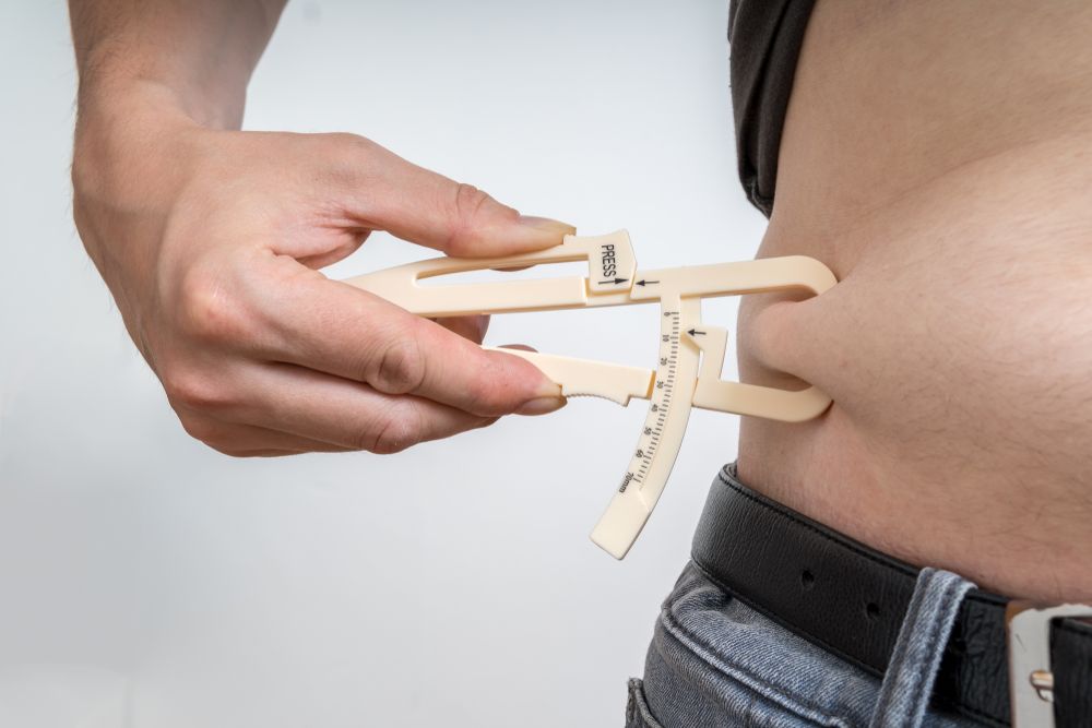 Man,Is,Measuring,Body,Fat,On,His,Belly,With,Caliper.