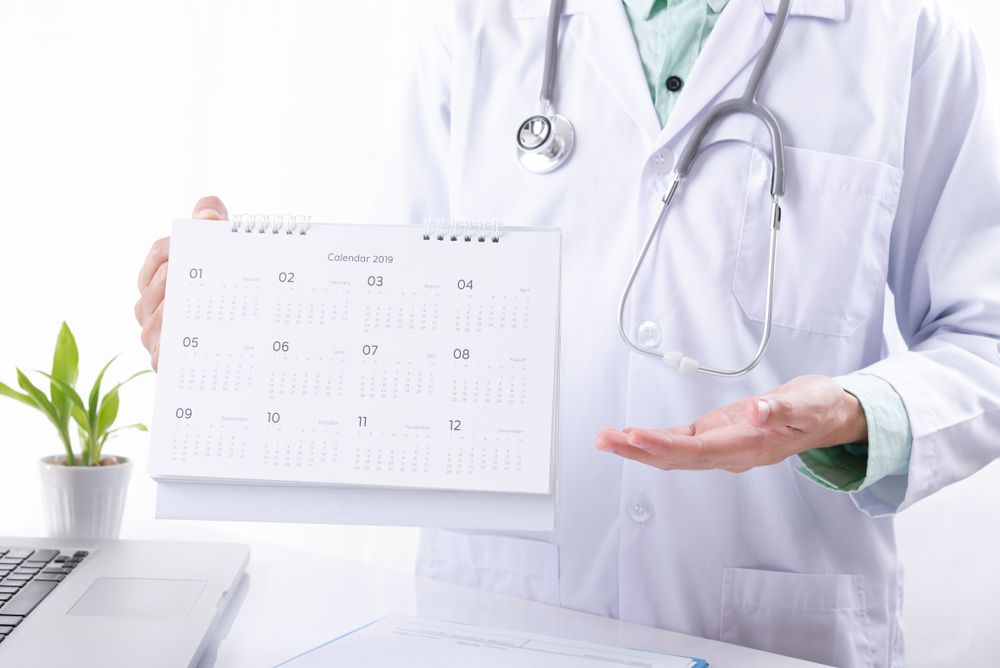 Doctor,Hand,Holding,Calendar,Appointment,For,Patient.,Concept,Planner,Health