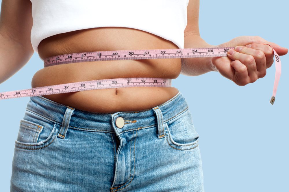 Overweight,Woman,With,Tape,Measure,Around,Waist,On,Pastel,Blue