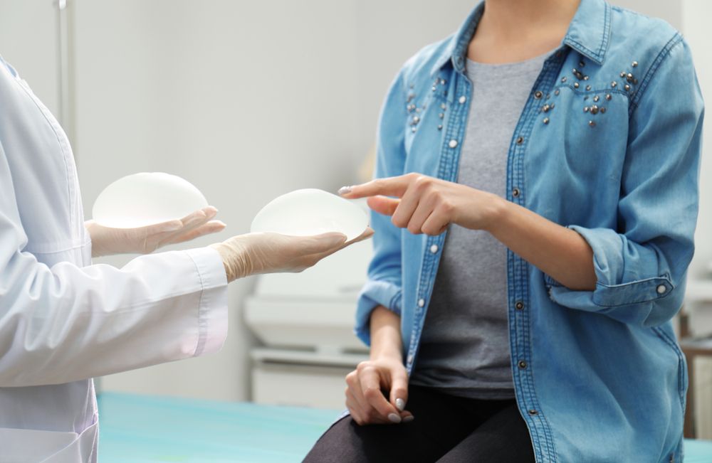 Doctor,Showing,Silicone,Implants,For,Breast,Augmentation,To,Patient,In