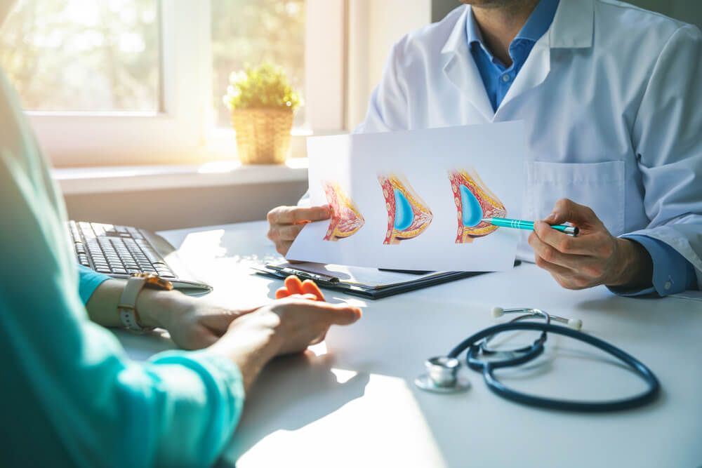 doctor consulting female patient about planned breast plastic surgery