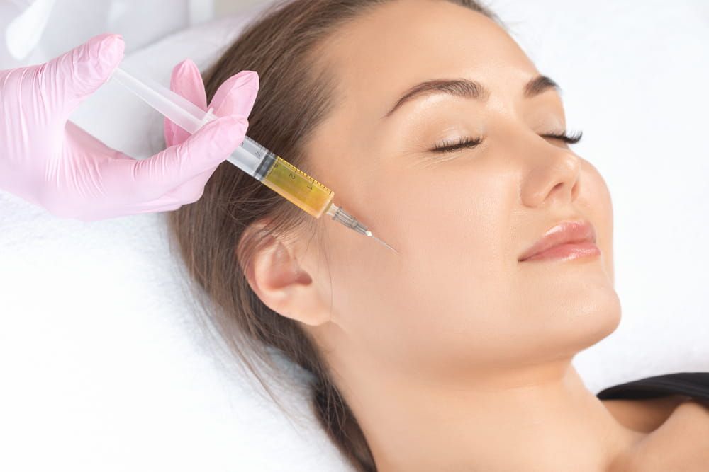 Cosmetologist does prp therapy on the face of a beautiful woman in a beauty salon. Cosmetology concept.