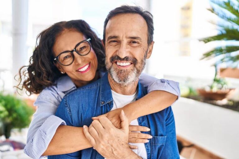 Middle age hispanic couple smiling confident hugging each other