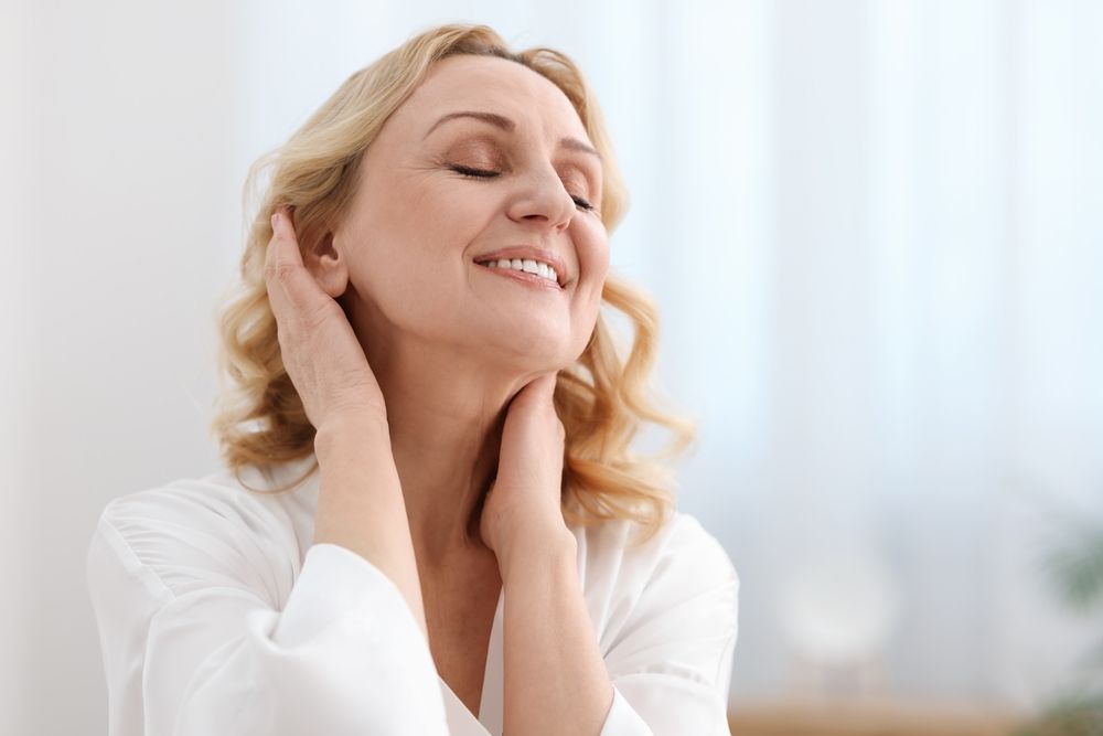 A smiling, middle-aged woman at home, with a space for text
