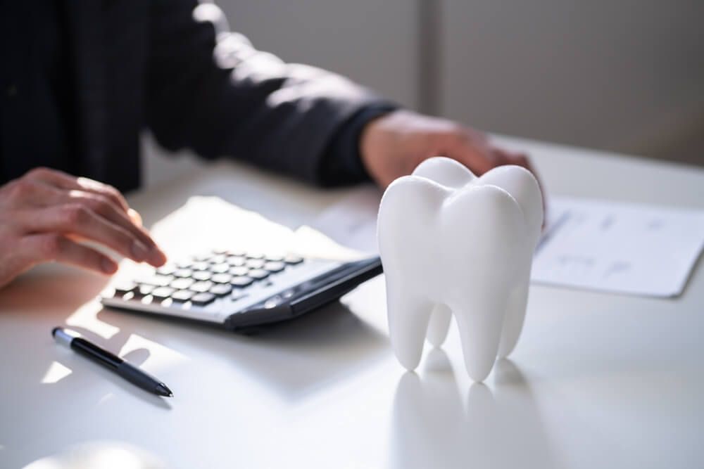 Dentist calculating dental Insurance Bill And Finance