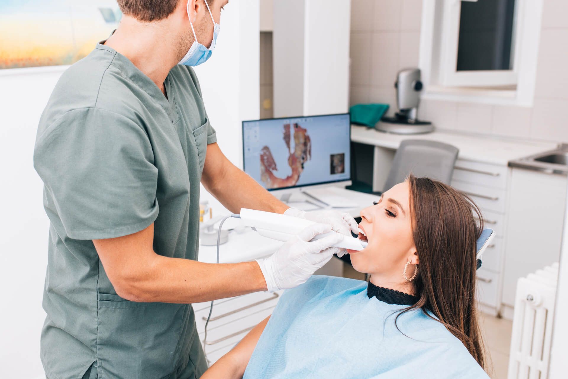The dentist scans the patient's teeth with a 3d scanner