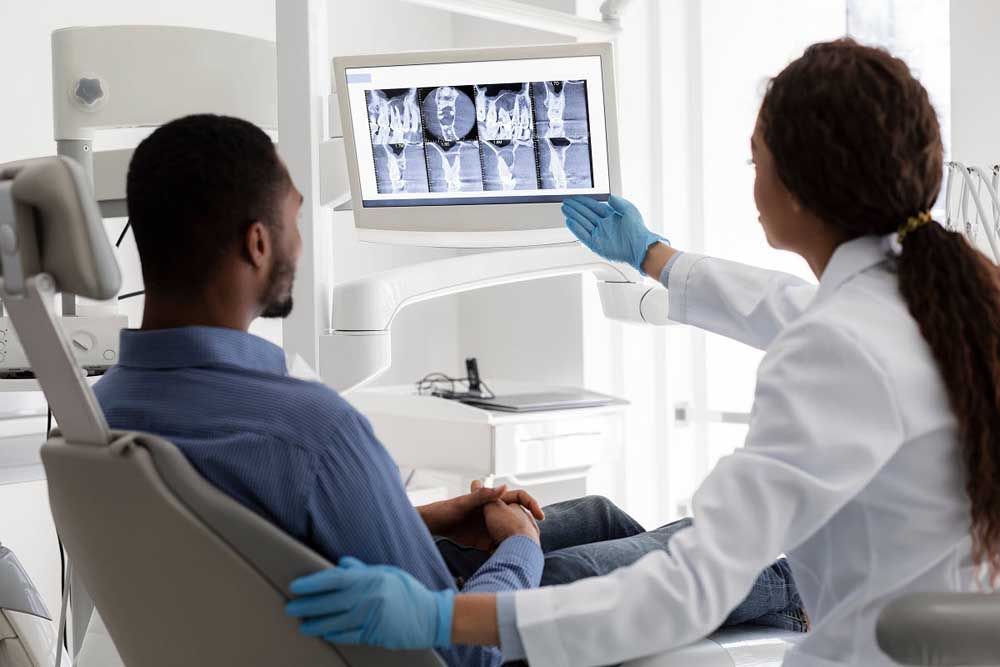 Female dentist pointing at screen with xray picture