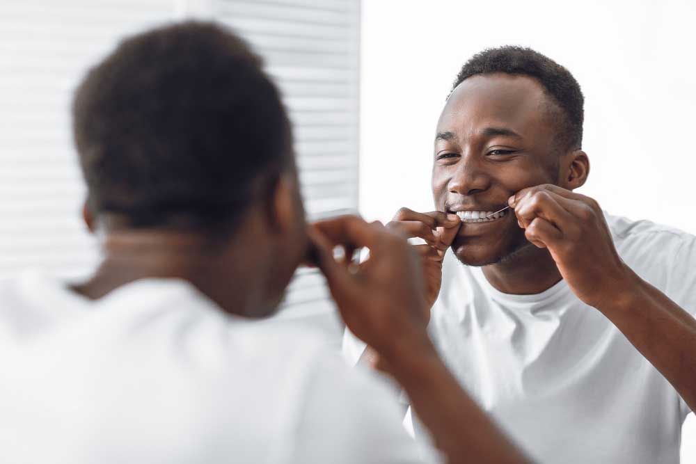 Man Flossing And Cleaning Teeth Using Tooth Floss