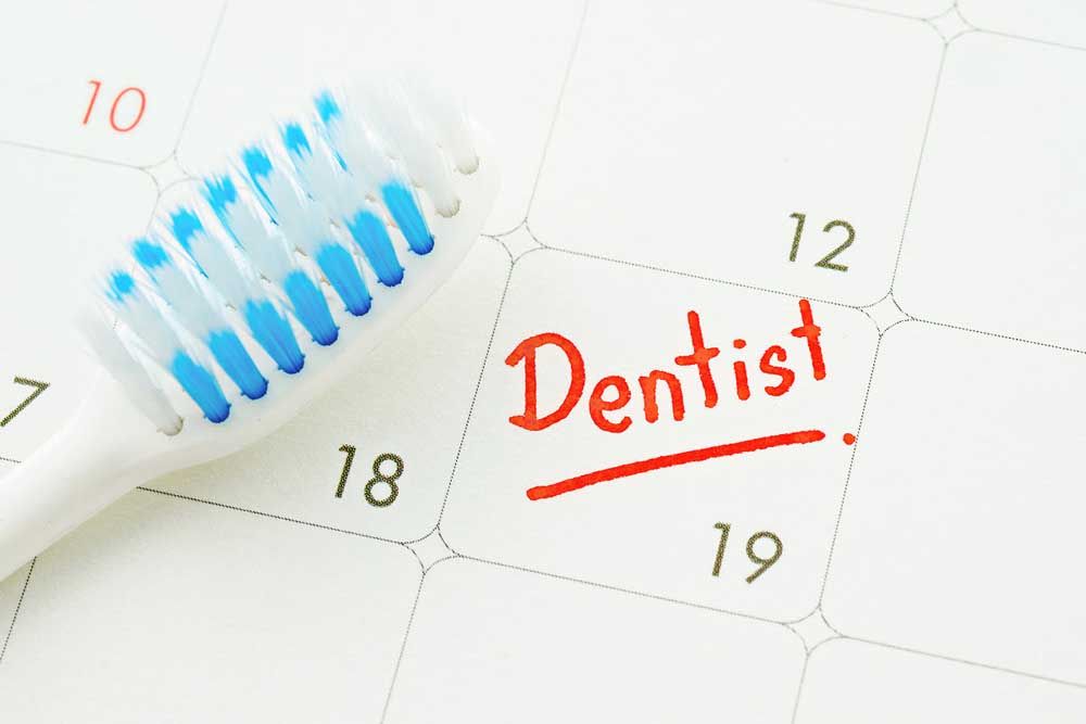 toothbrush on dentist appointment reminder on a calendar page