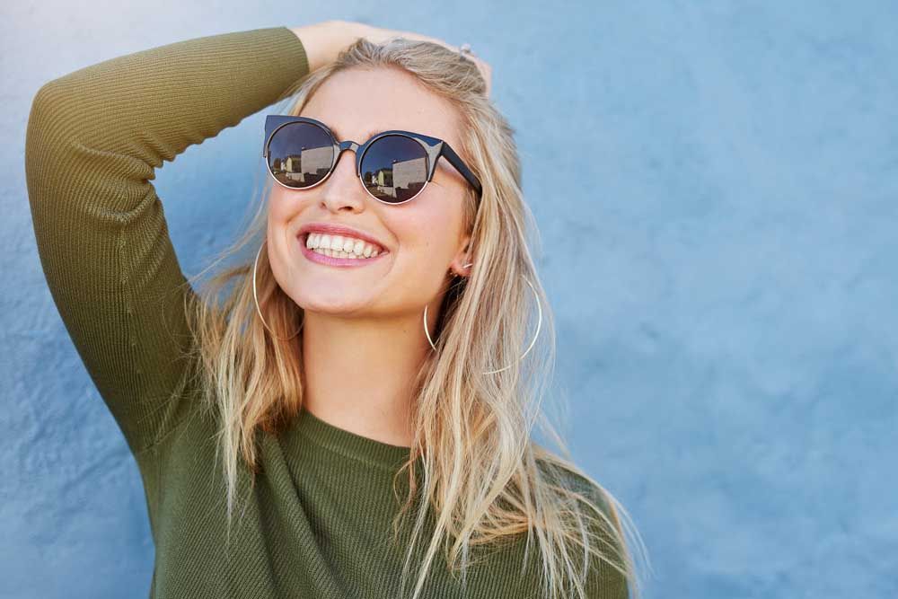 stylish young woman in sunglasses smiling