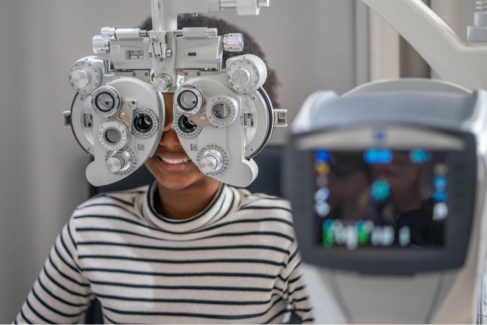 Close-up Of african teen girl Doing Eye Test On Phoropter,