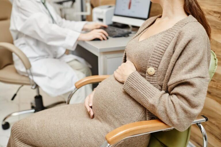 Cropped shot of pregnant young woman consulting obgyn