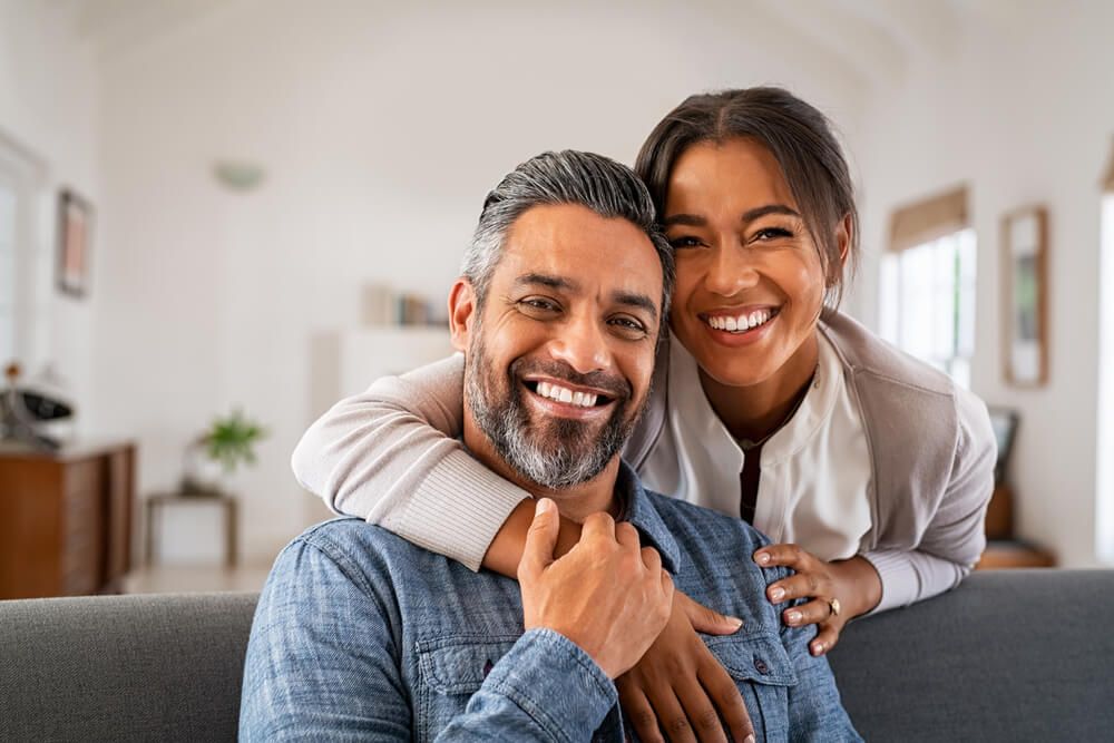 Portrait of multiethnic couple embracing and looking at camera
