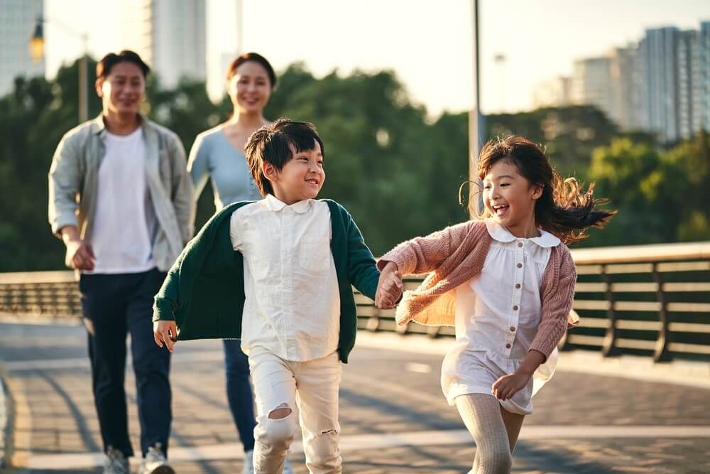 happy family with two children walking on pedestrian bridge