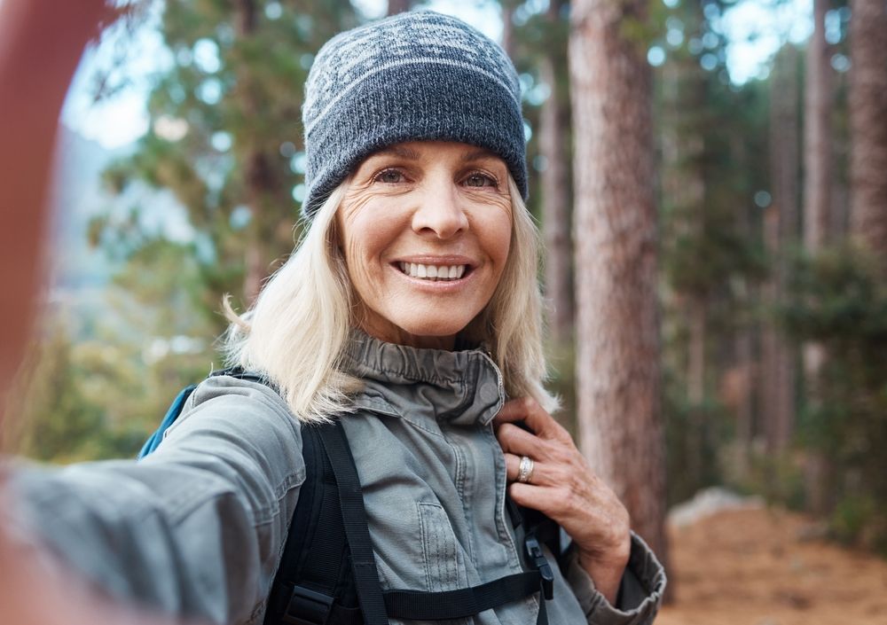 Smiling senior woman in the forest for fitness