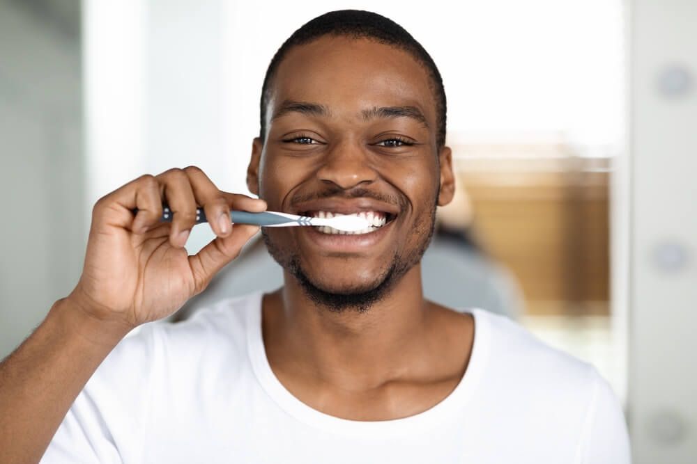 Joyful Guy Brushing Teeth With Toothbrush